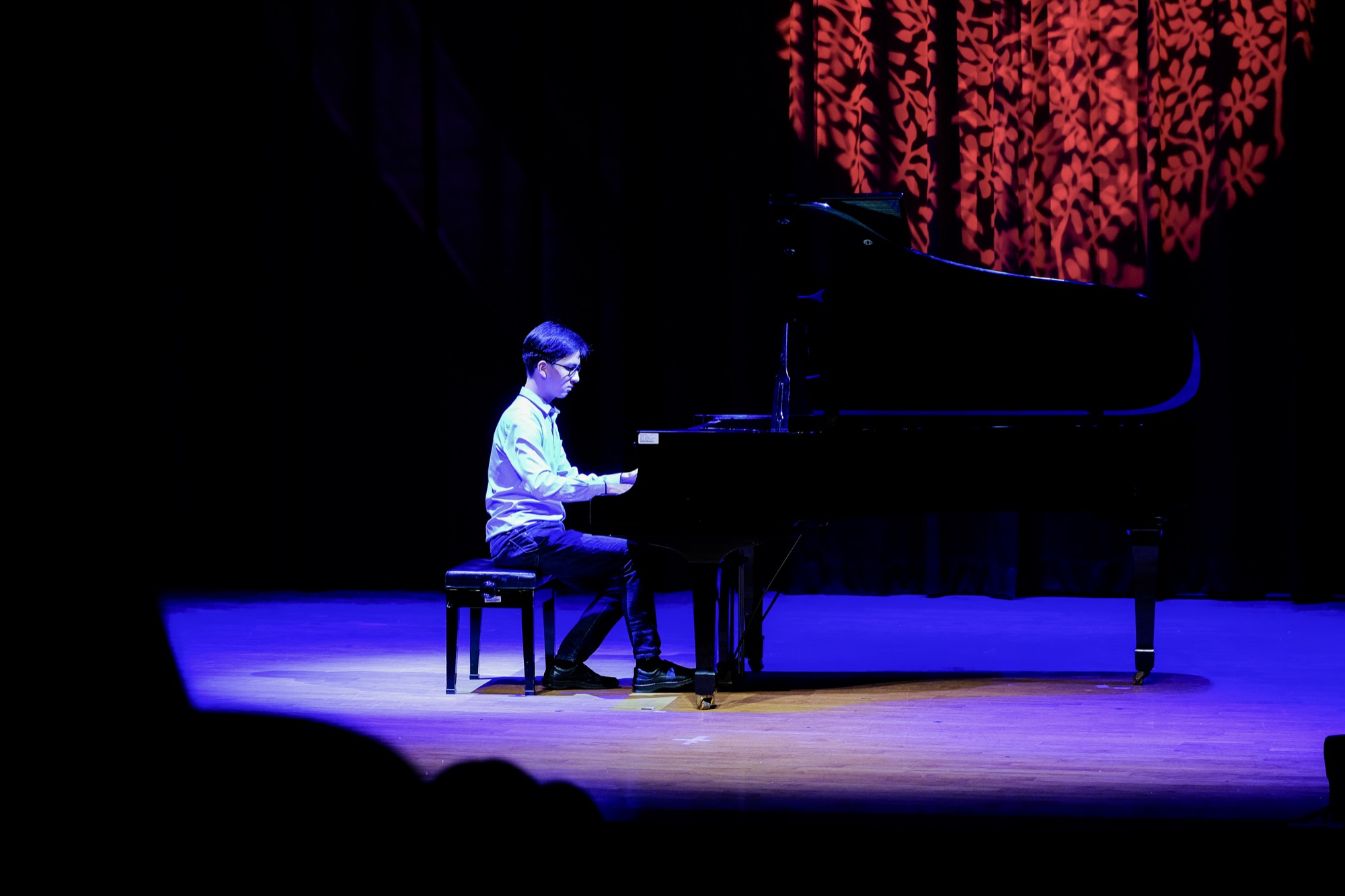 Andrew Huang duduk di piano grand semasa resital