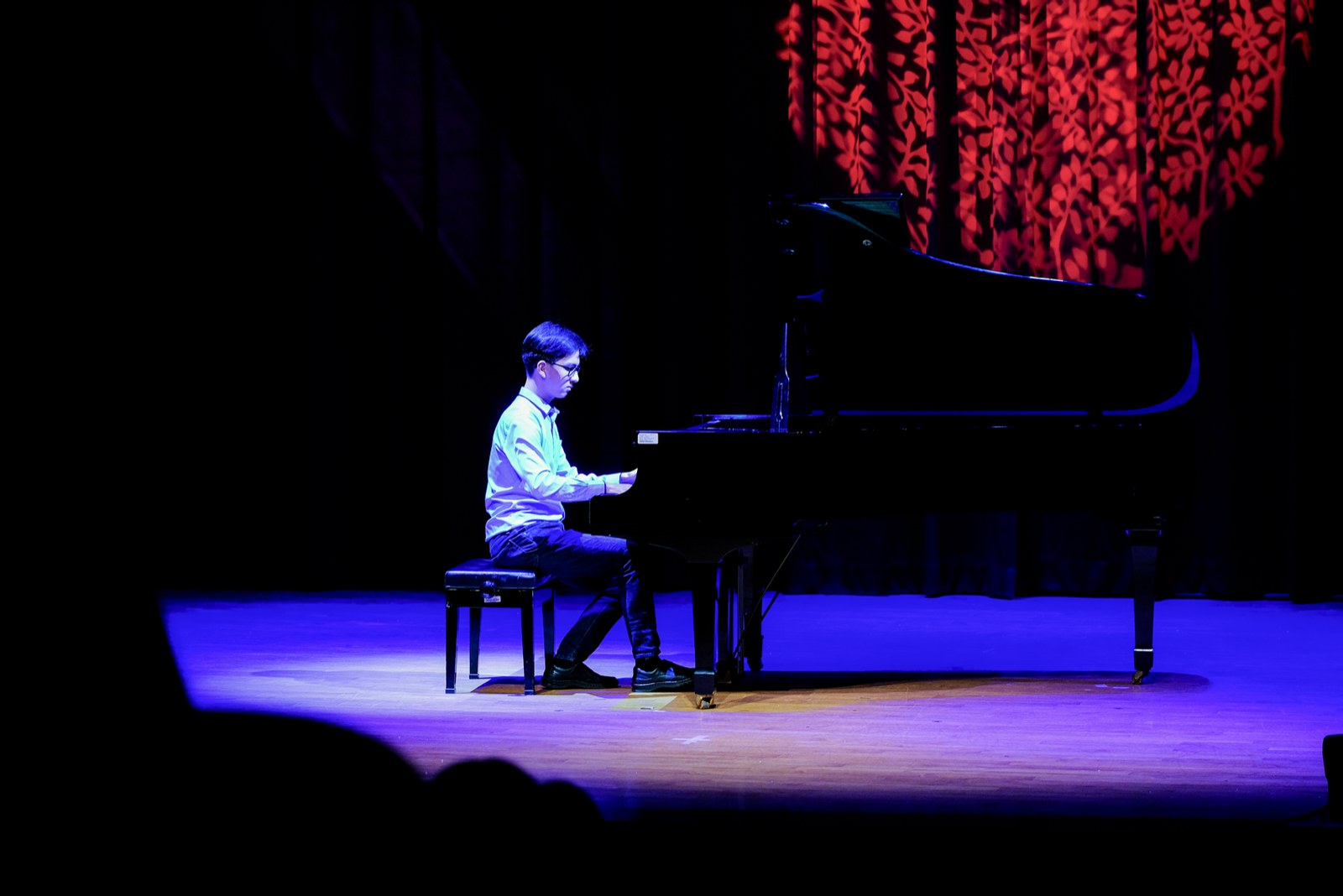 Andrew Huang on stage at the grand piano during a recital